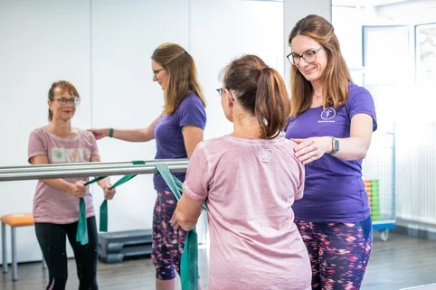 Schülerin begleitet eine Patientin bei einer Übung mit dem Theraband. Schülerin begleitet eine Patientin bei einer Übung mit dem Theraband.