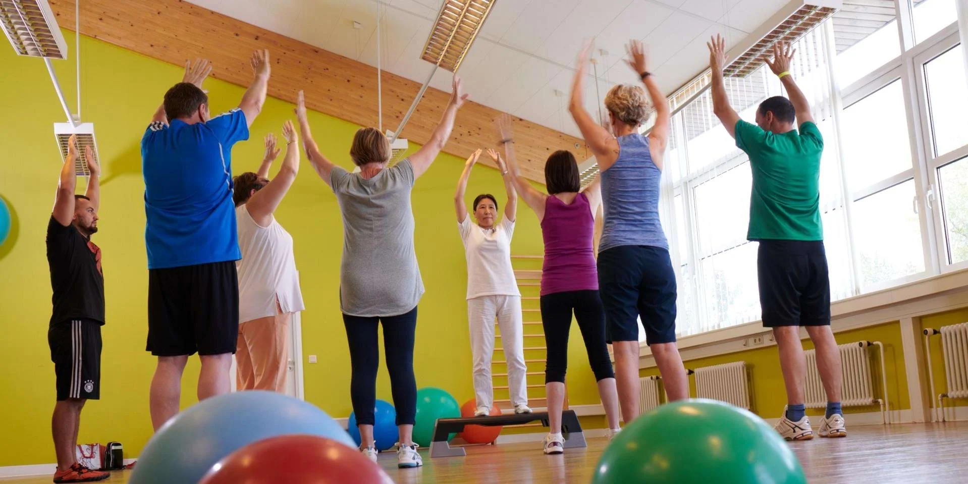 Physiotherapiekurs mit Pezzi Bällen und mehreren Teilnehmern, die im Kreis stehen Physiotherapiekurs mit Pezzi Bällen und mehreren Teilnehmern, die im Kreis stehen