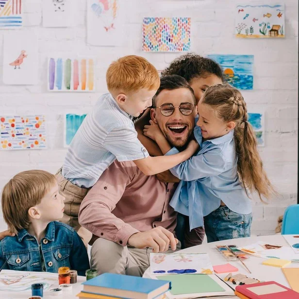 Kita-Leitung wird von mehreren Kindern umarmt. Kita-Leitung wird von mehreren Kindern umarmt.