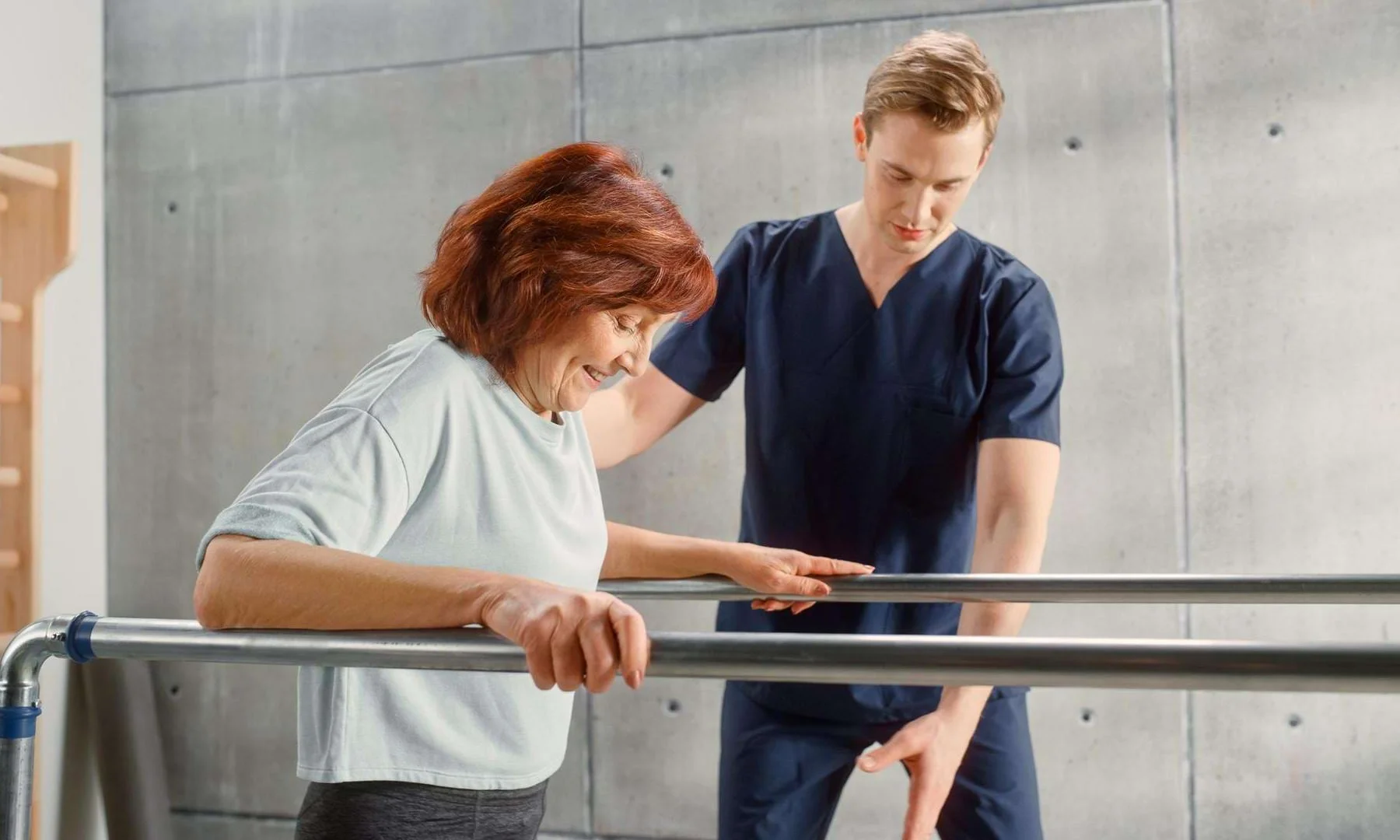 Physiotherapeut begleitet eine Patientin bei Gehübungen im Anpassungslehrgang Physiotherapie.