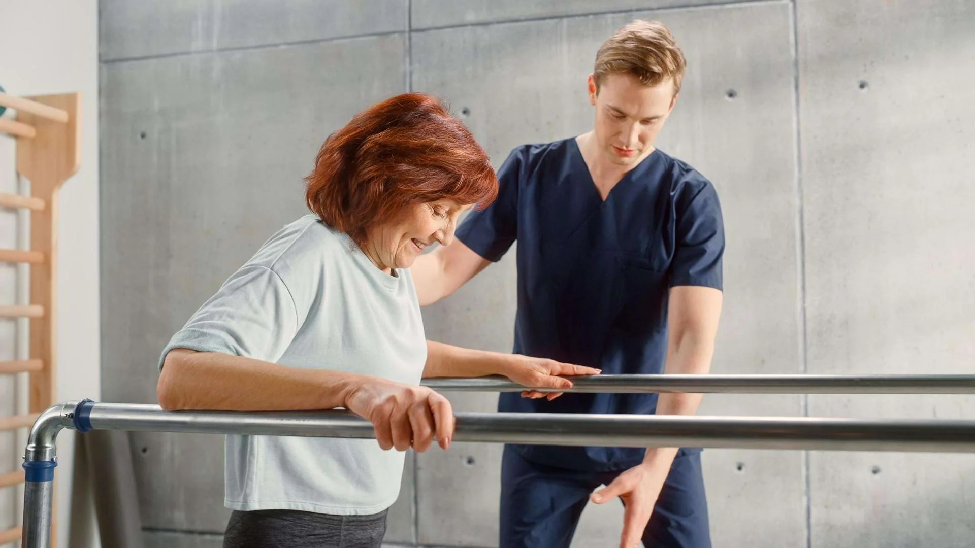 Physiotherapeut begleitet eine Patientin bei Gehübungen im Anpassungslehrgang Physiotherapie.
