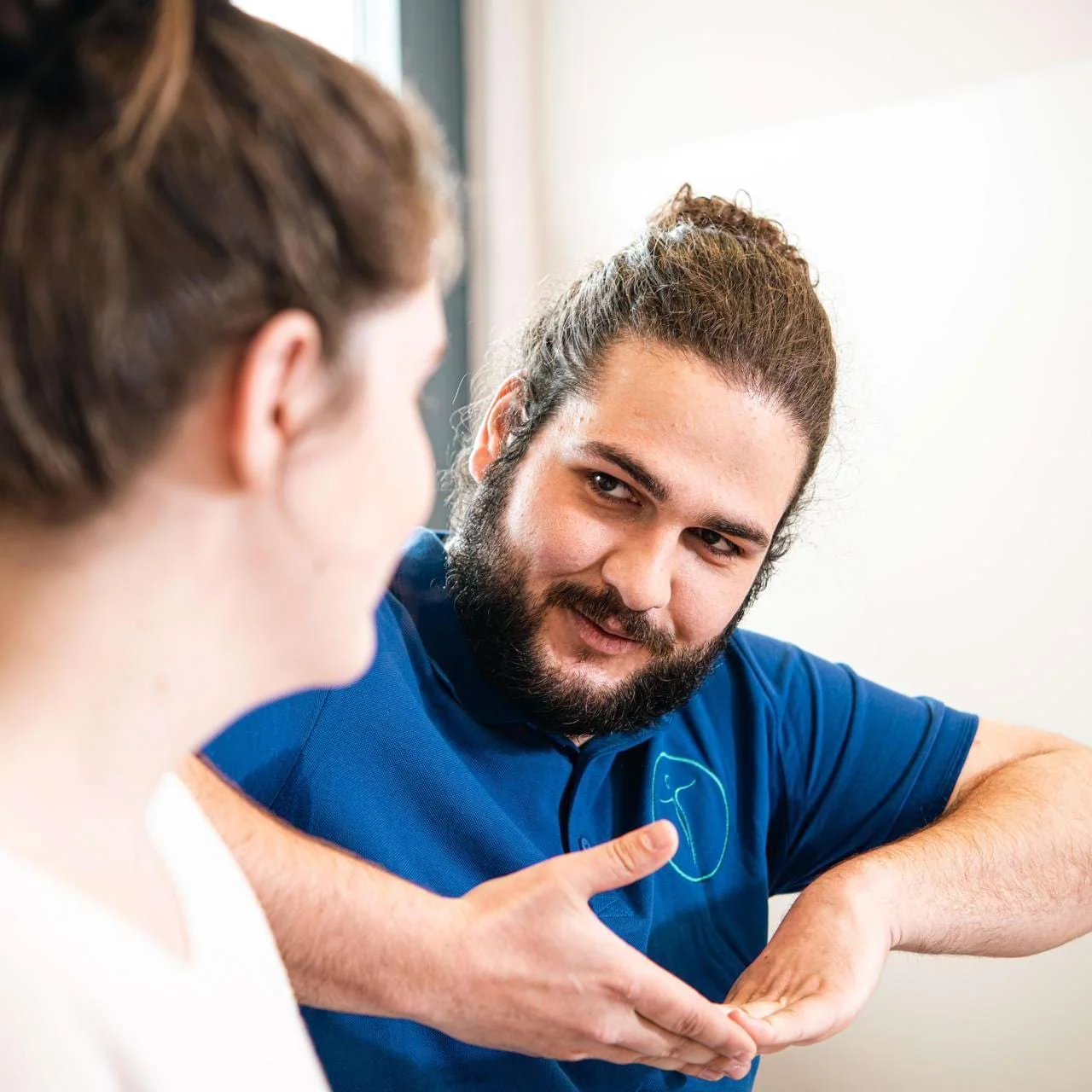 Neurotherapeut zeigt Patientin Handgriff