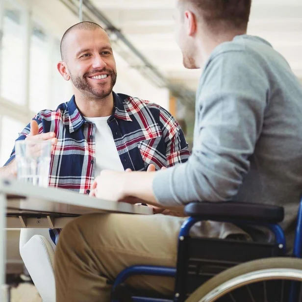 Sozialarbeiter spricht mit einem Patienten im Rollstuhl. Sozialarbeiter spricht mit einem Patienten im Rollstuhl.
