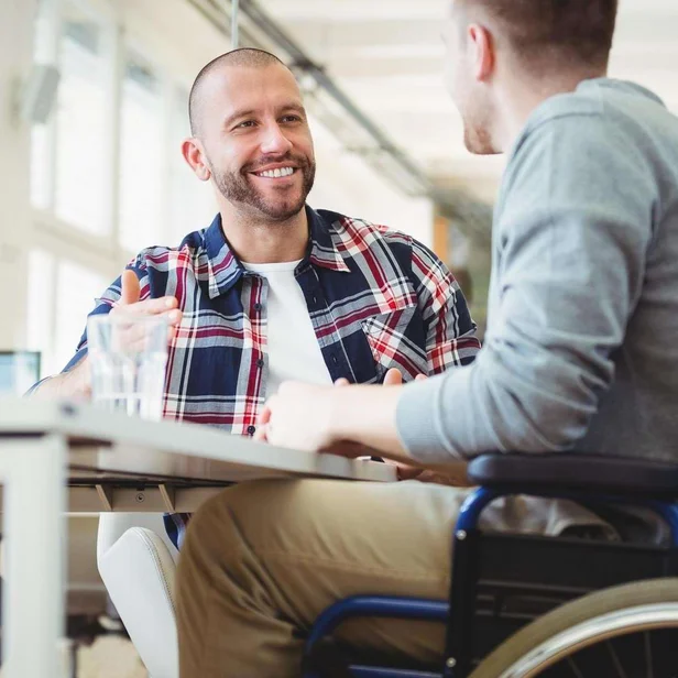 Sozialarbeiter spricht mit einem Patienten im Rollstuhl. Sozialarbeiter spricht mit einem Patienten im Rollstuhl.