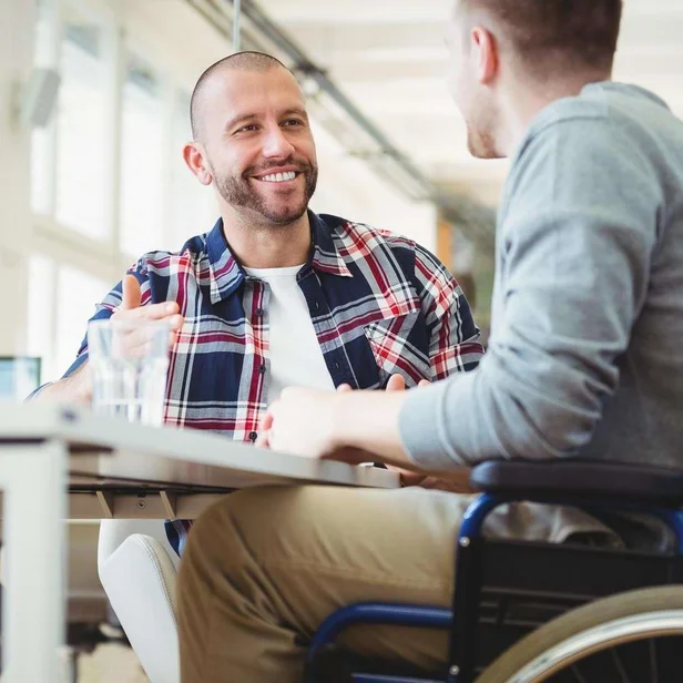 Personaler spricht mit einem Mitarbeiter im Rollstuhl. Personaler spricht mit einem Mitarbeiter im Rollstuhl.