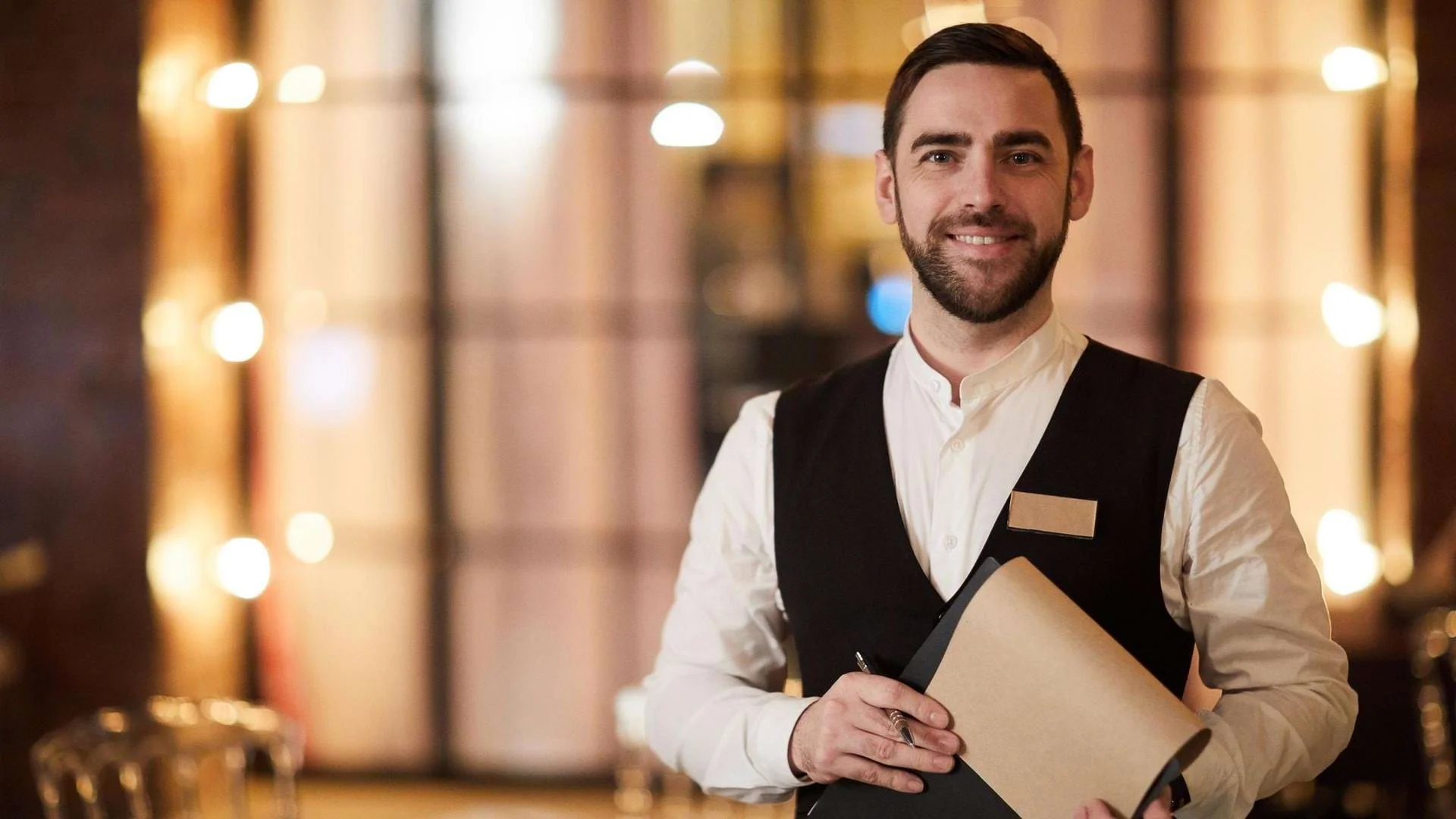 Ein Auszubildender zur Fachkraft für Gastronomie übernimmt Verantwortung im Service., Bild öffnen