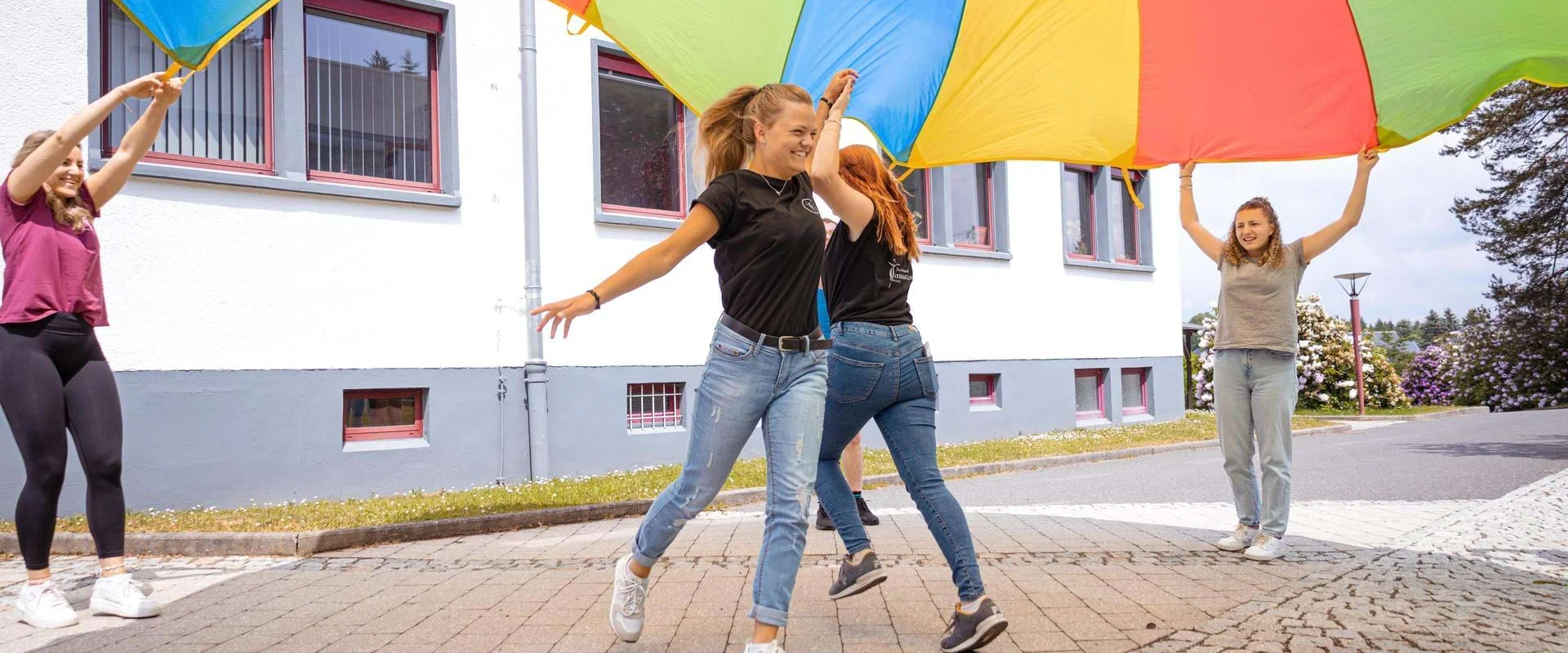 Auszubildende Ergotherapie laufen unter einem Tuch hindurch.
