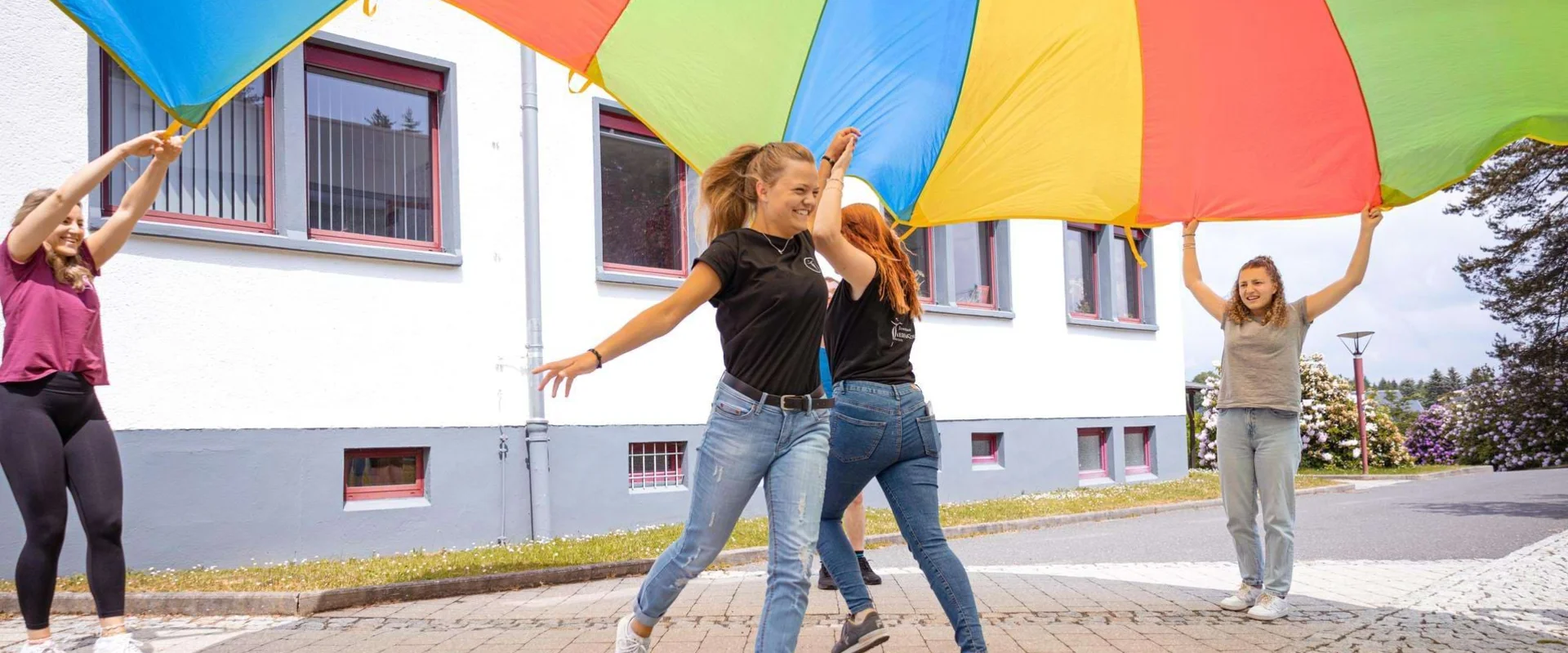 Auszubildende Ergotherapie laufen unter einem Tuch hindurch. Auszubildende Ergotherapie laufen unter einem Tuch hindurch.