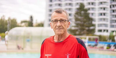 Portrait von Badeaufsicht Josef Kieweg vor einem Schwimmbecken