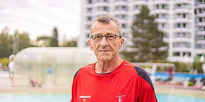 Portrait von Badeaufsicht Josef Kieweg vor einem Schwimmbecken