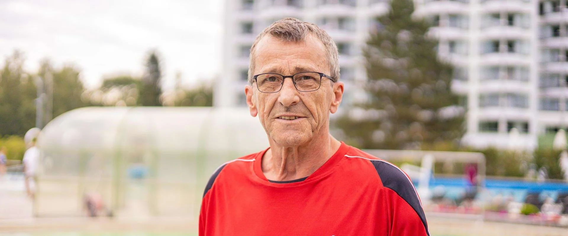 Portrait von Badeaufsicht Josef Kieweg vor einem Schwimmbecken