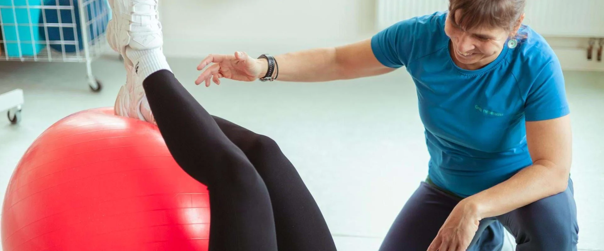 Physiotherapeutin Gesa Heinemann zeigt eine Gleichgewichtsübung mit einem Pezziball.