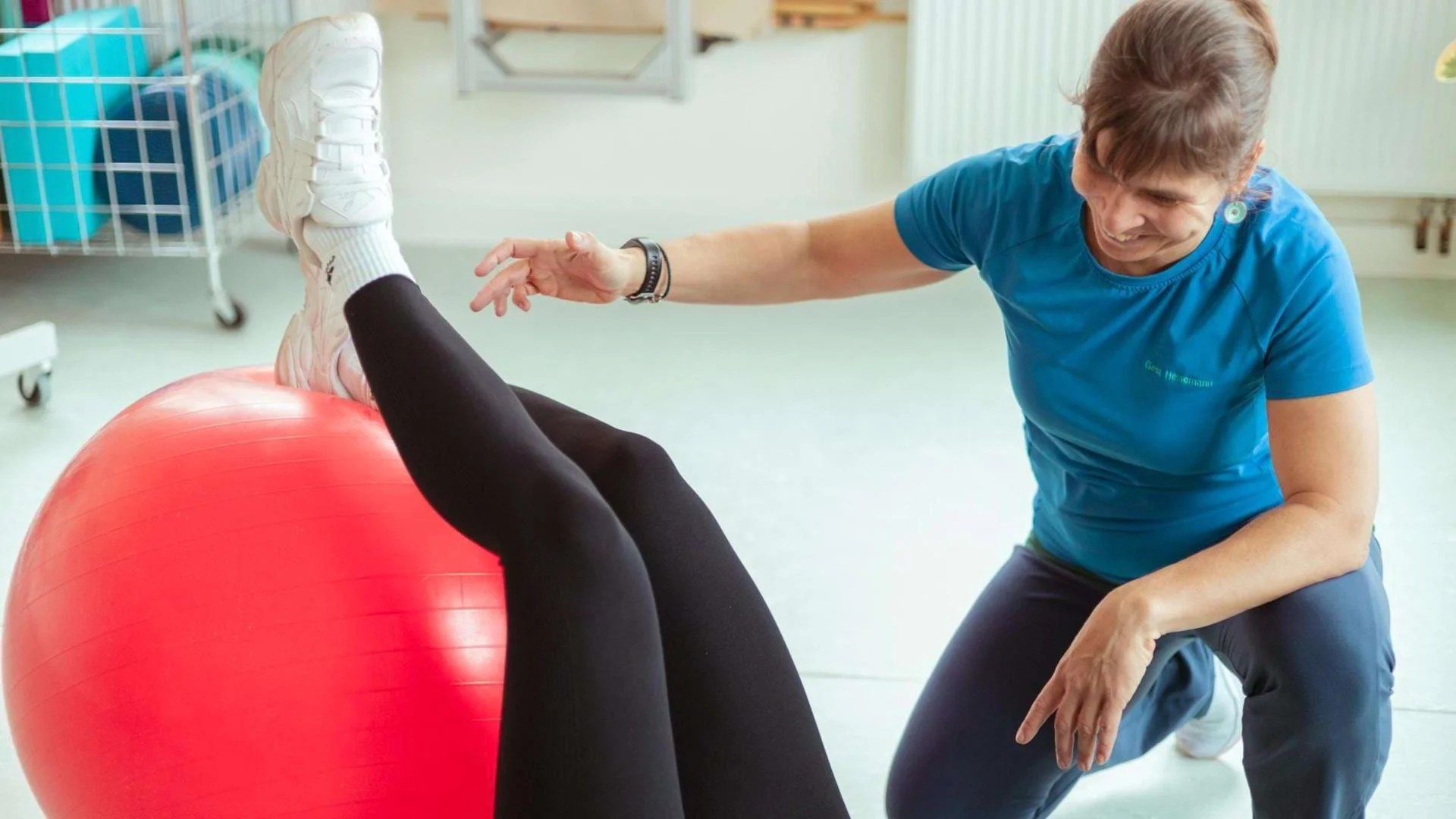 Physiotherapeutin Gesa Heinemann zeigt eine Gleichgewichtsübung mit einem Pezziball.