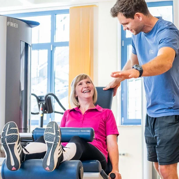 Sporttherapeut betreut eine Patientin bei einer Geräteübung. Sporttherapeut betreut eine Patientin bei einer Geräteübung.