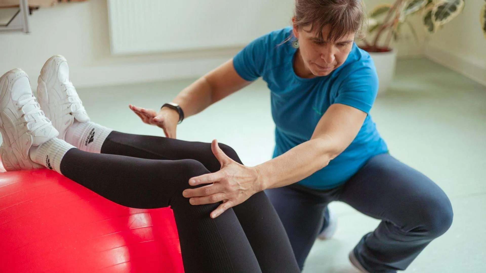 Physiotherapeutin Gesa Heinemann zeigt eine Gleichgewichtsübung mit einem Pezziball.