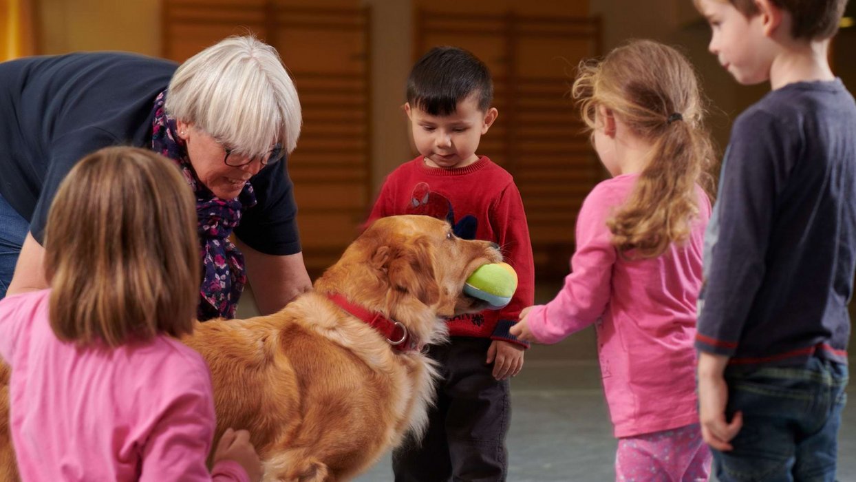 Therapeutin der Johannesbad Fachklinik Hochsauerland in tiergestützter Therapie mit Therapiehund und Kindern