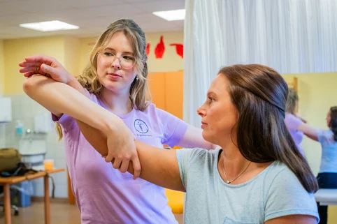 Ergotherapie-Schülerin begleitet eine Patientin bei Armübungen. Ergotherapie-Schülerin begleitet eine Patientin bei Armübungen.