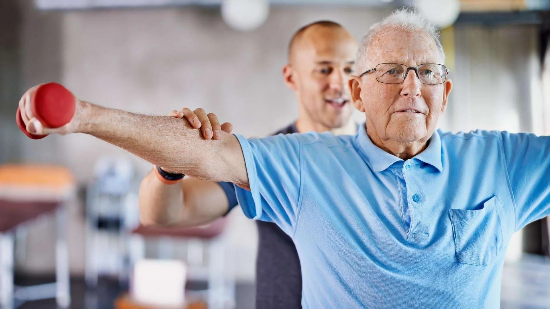 Physiotherapeut begleitet einen Patienten bei einer Übung im Anpassungslehrgang Physiotherapie., Bild öffnen