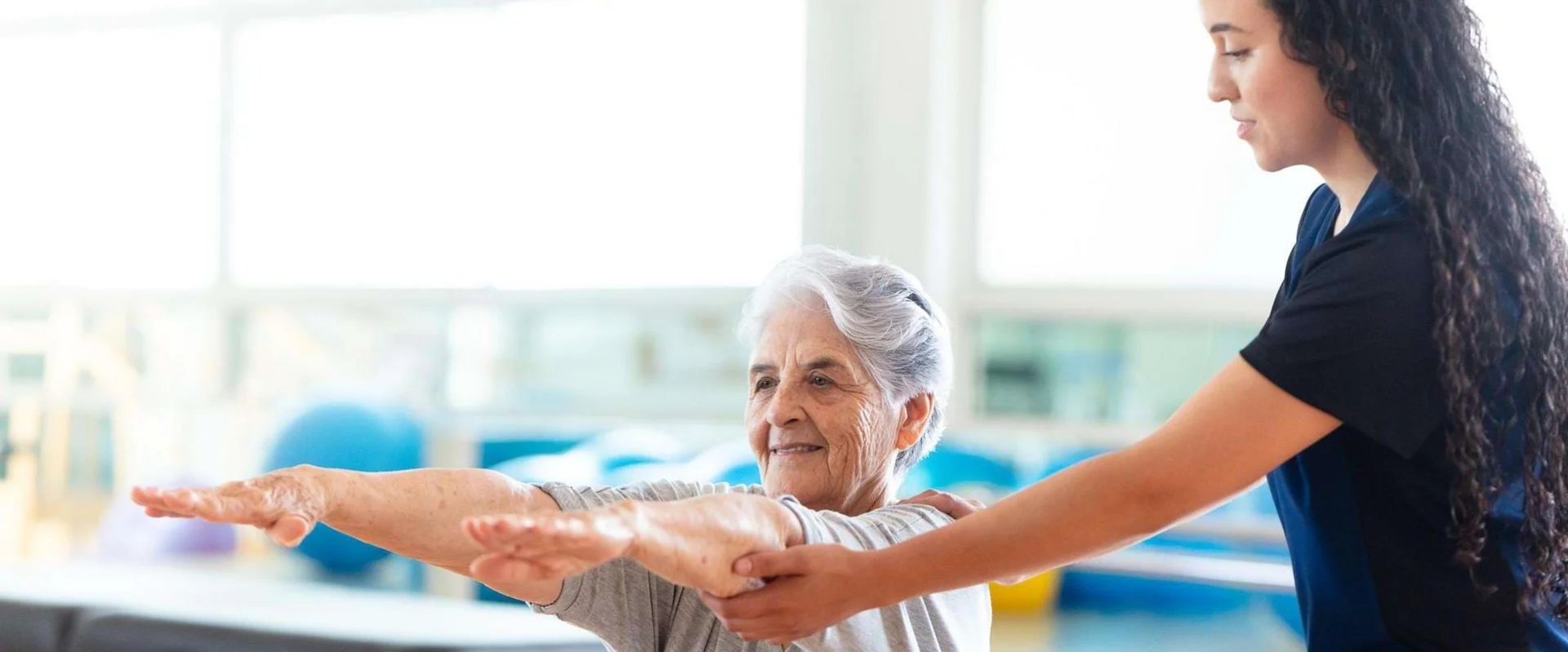 Physiotherapeutin begleitet einen Patienten bei einer Übung im Anpassungslehrgang Physiotherapie.