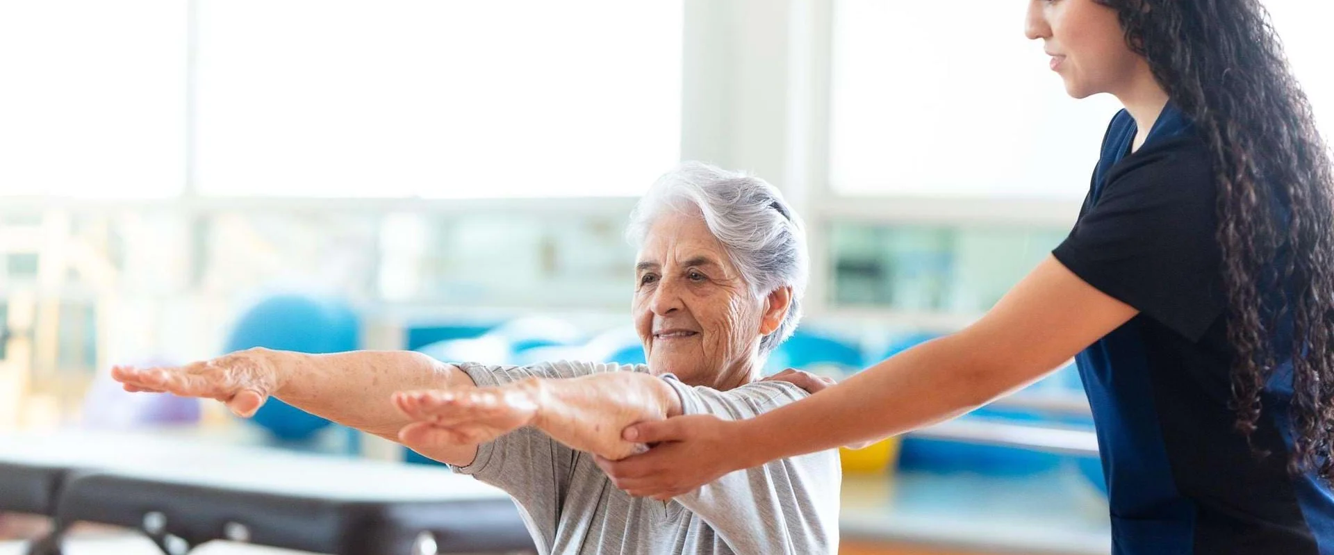 Physiotherapeutin begleitet einen Patienten bei einer Übung im Anpassungslehrgang Physiotherapie.