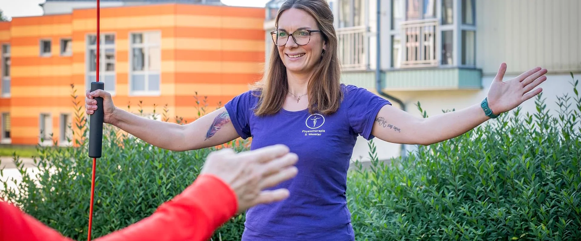 Physiotherapeutin Sarah Wessler zeigt eine aktive Übung zur Schulterbeweglichkeit. Physiotherapeutin Sarah Wessler zeigt eine aktive Übung zur Schulterbeweglichkeit.