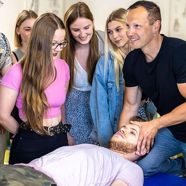 Lehrer erklärt Schülern anatomische Inhalte in der Therapieausbildung.
