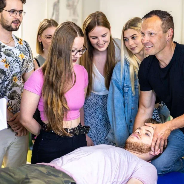 Lehrer erklärt Schülern anatomische Inhalte in der Therapieausbildung.