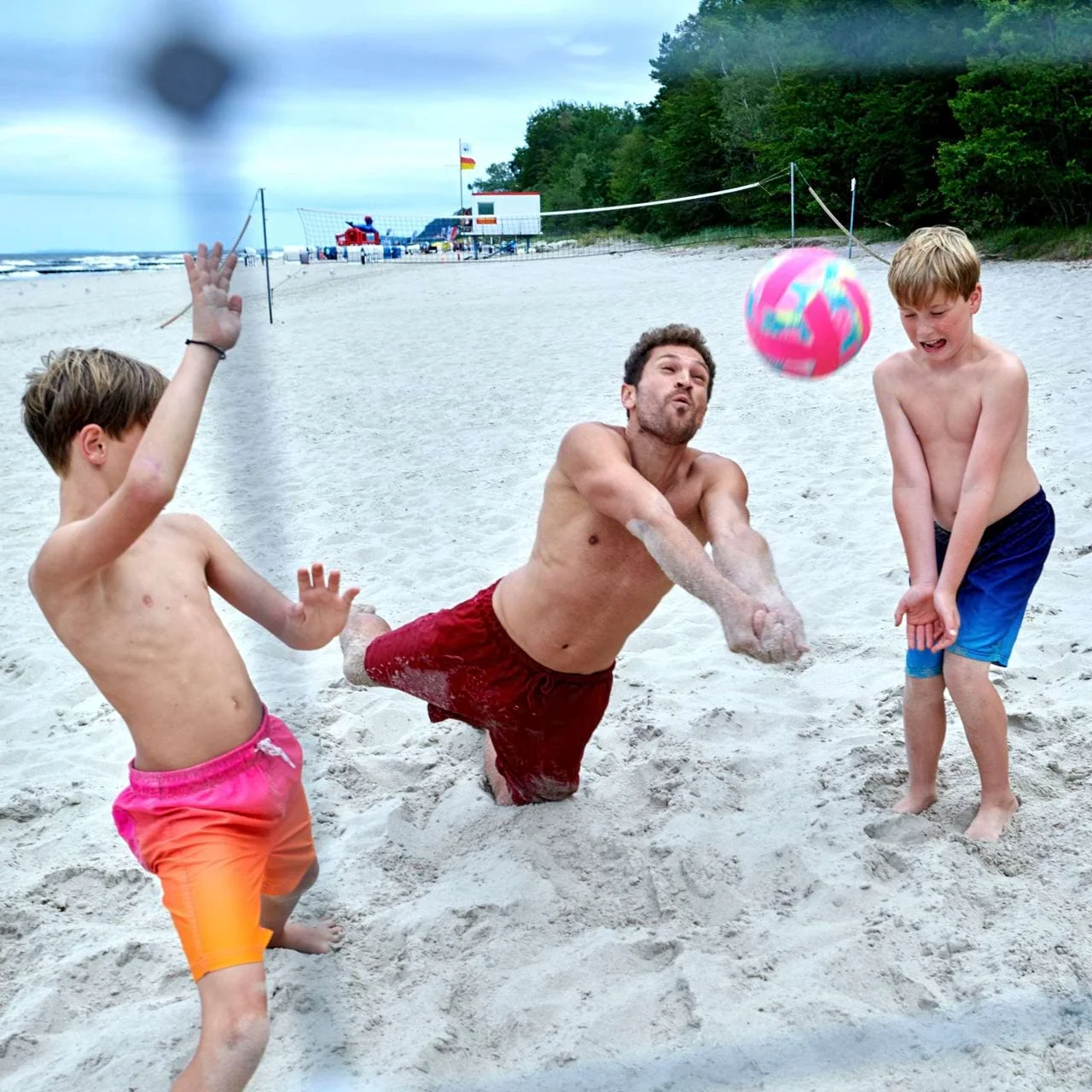 Vater und Kinder spielen Beach-Volleyball in Johannesbad Fachklinik Usedom