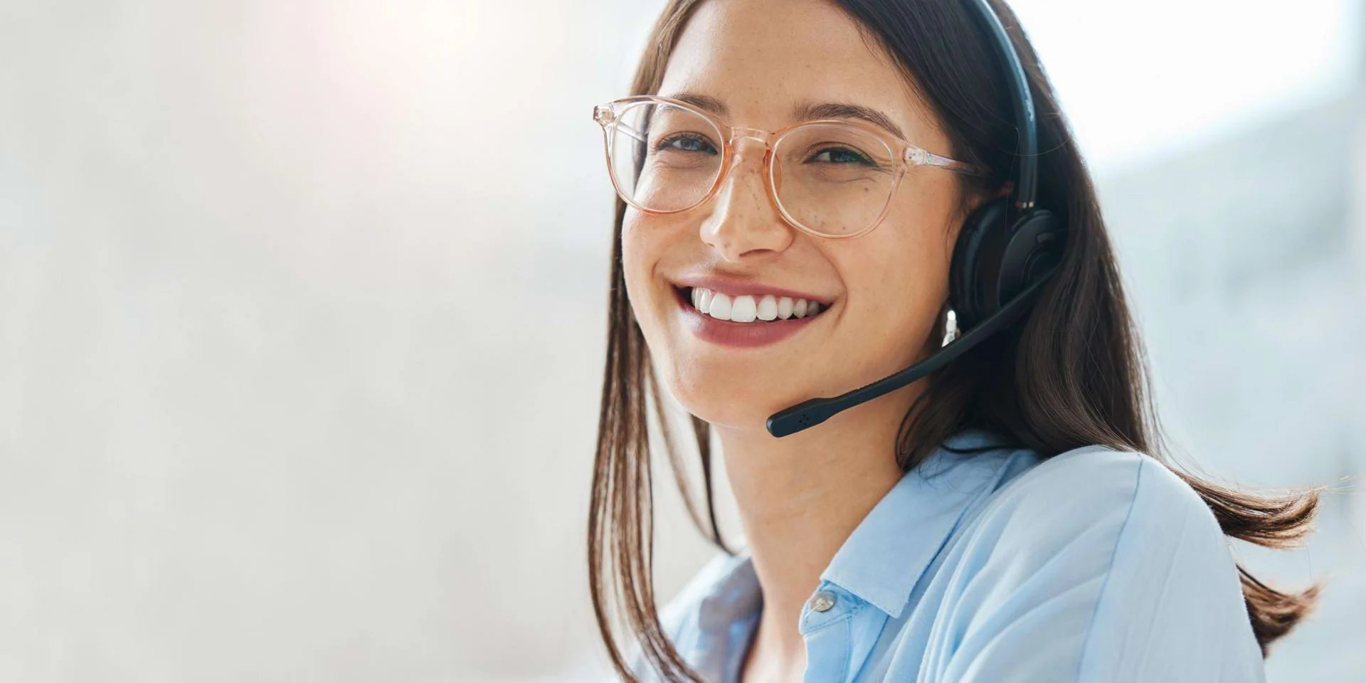 Frau mit Headset lächelt in Kamera
