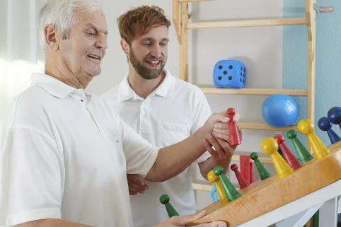 Ergotherapie-Schüler üben mit einem Patienten eine Geschicklichkeitsübung. Ergotherapie-Schüler üben mit einem Patienten eine Geschicklichkeitsübung.