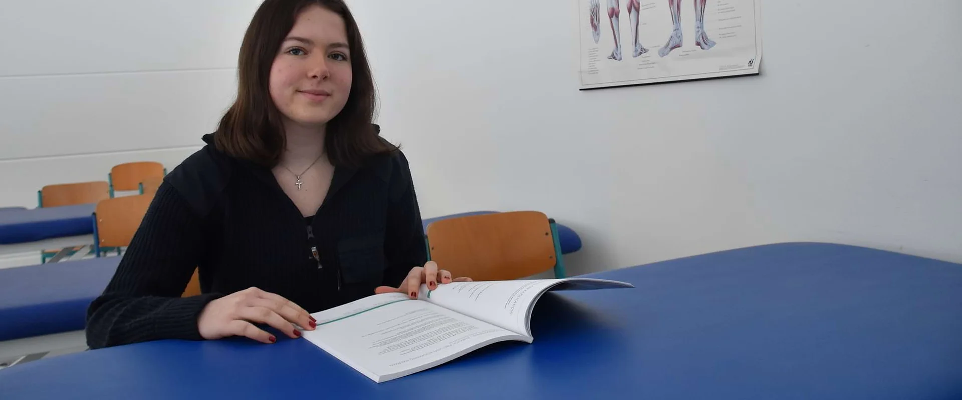 Schülerin Ida sitzt an einem Tisch vor einem Lehrbuch