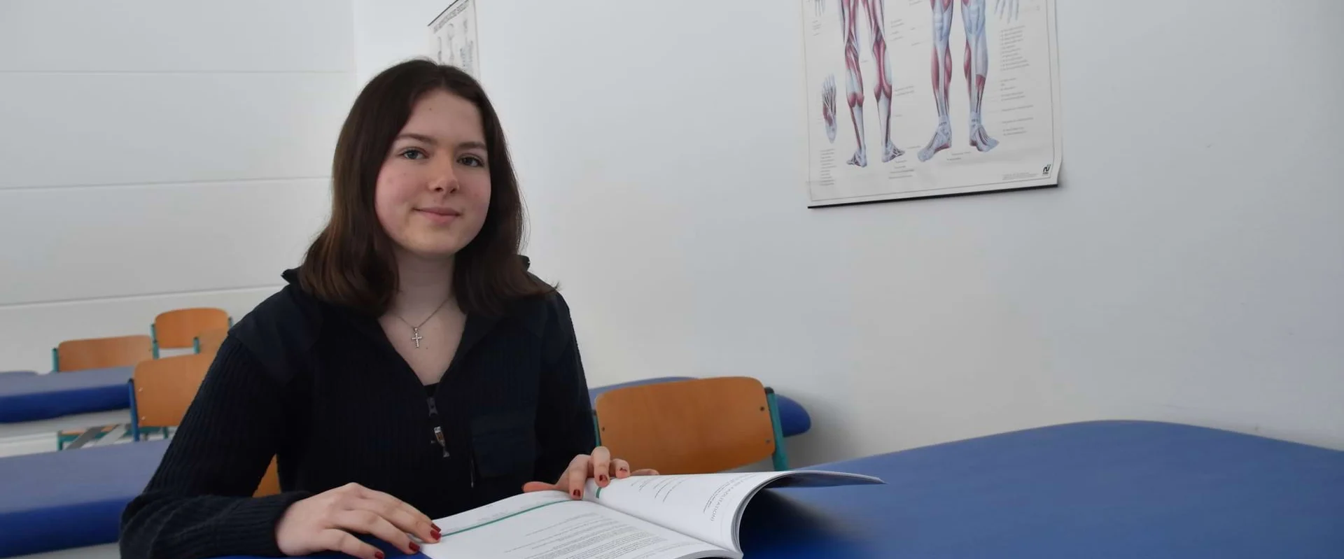 Schülerin Ida sitzt an einem Tisch vor einem Lehrbuch