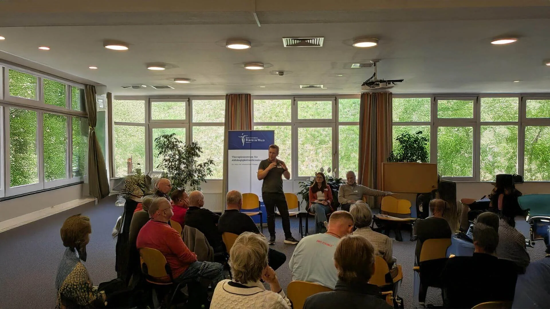Psychologe Simon Lössl, hält einen Vortrag vor einer Gruppe.
