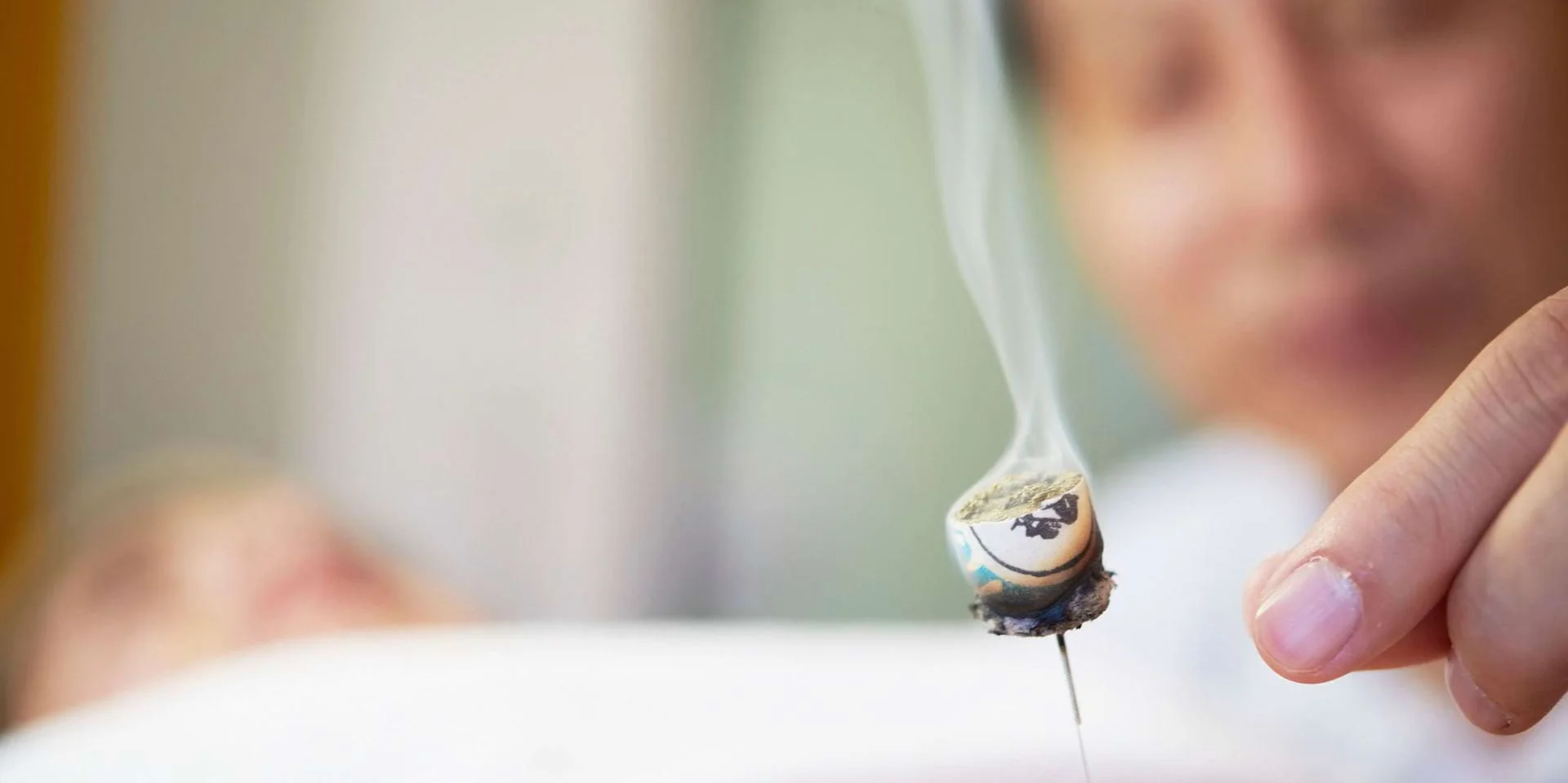 Rauchende Akkupunkturnadel bei einer TCM Behandlung Rauchende Akkupunkturnadel bei einer TCM Behandlung