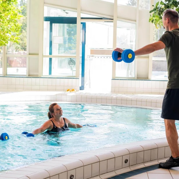 Medizinischer Bademeister leitet einen Aqua-Fitness-Kurs. Medizinischer Bademeister leitet einen Aqua-Fitness-Kurs.