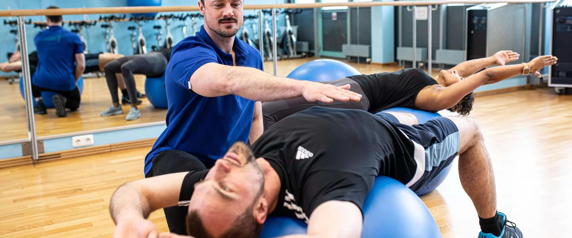 Physiotherapeut begleitet einen Patienten bei Übungen mit dem Pezziball. Physiotherapeut begleitet einen Patienten bei Übungen mit dem Pezziball.