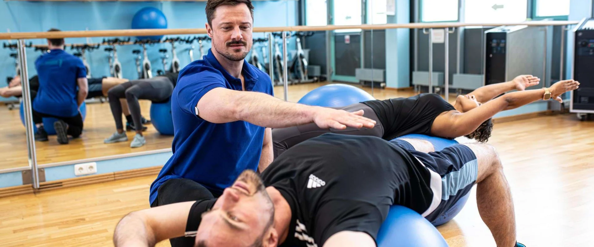 Physiotherapeut begleitet einen Patienten bei Übungen mit dem Pezziball.