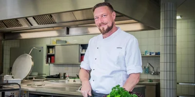 Eric Schimmel steht in der Küche und bereitet frische Zutaten zu.