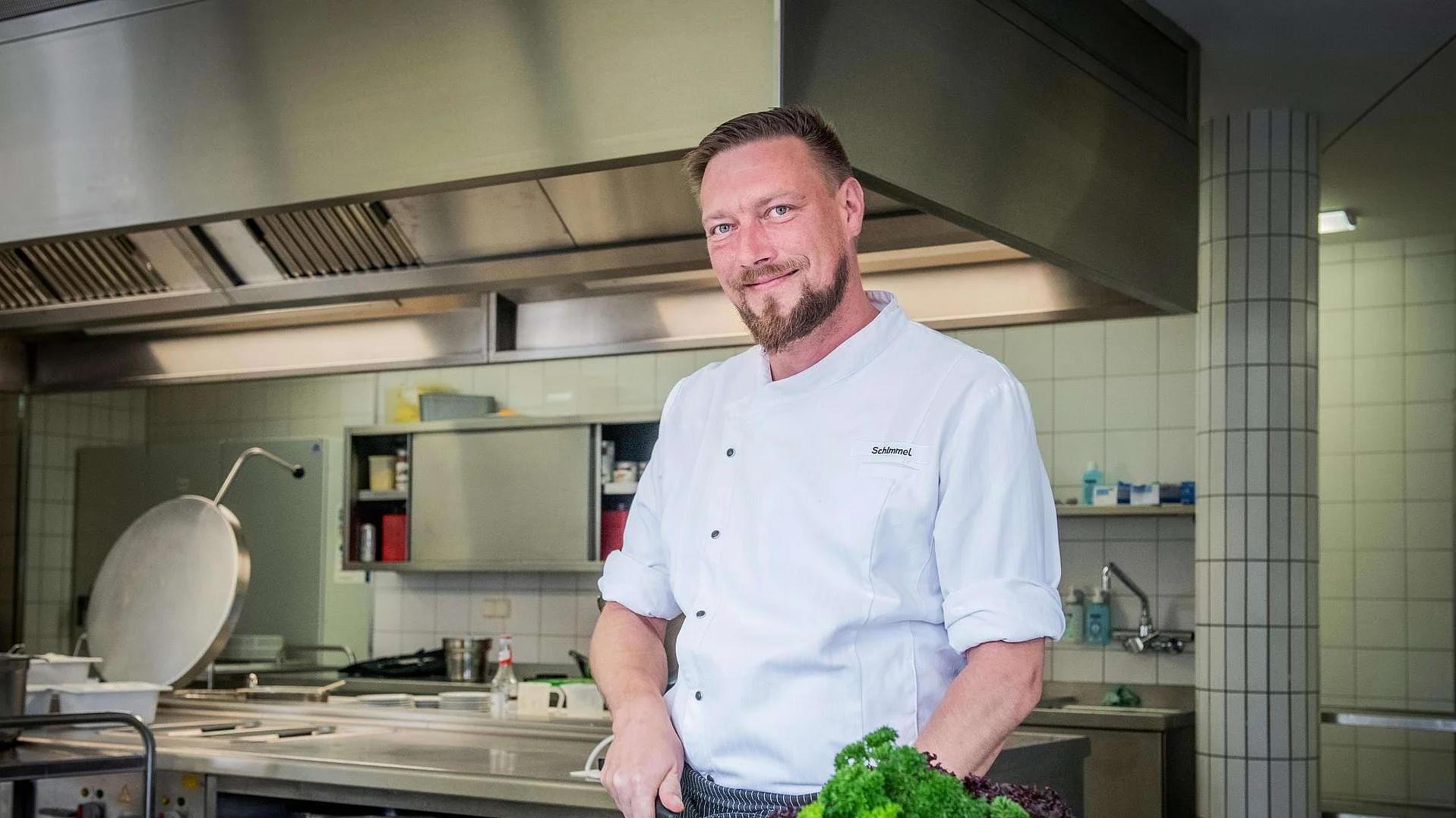 Eric Schimmel steht in der Küche und bereitet frische Zutaten zu.