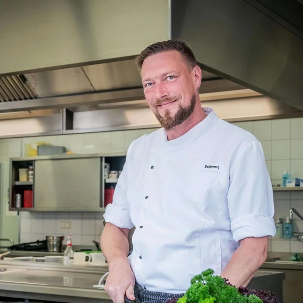Eric Schimmel steht in der Küche und bereitet frische Zutaten zu.