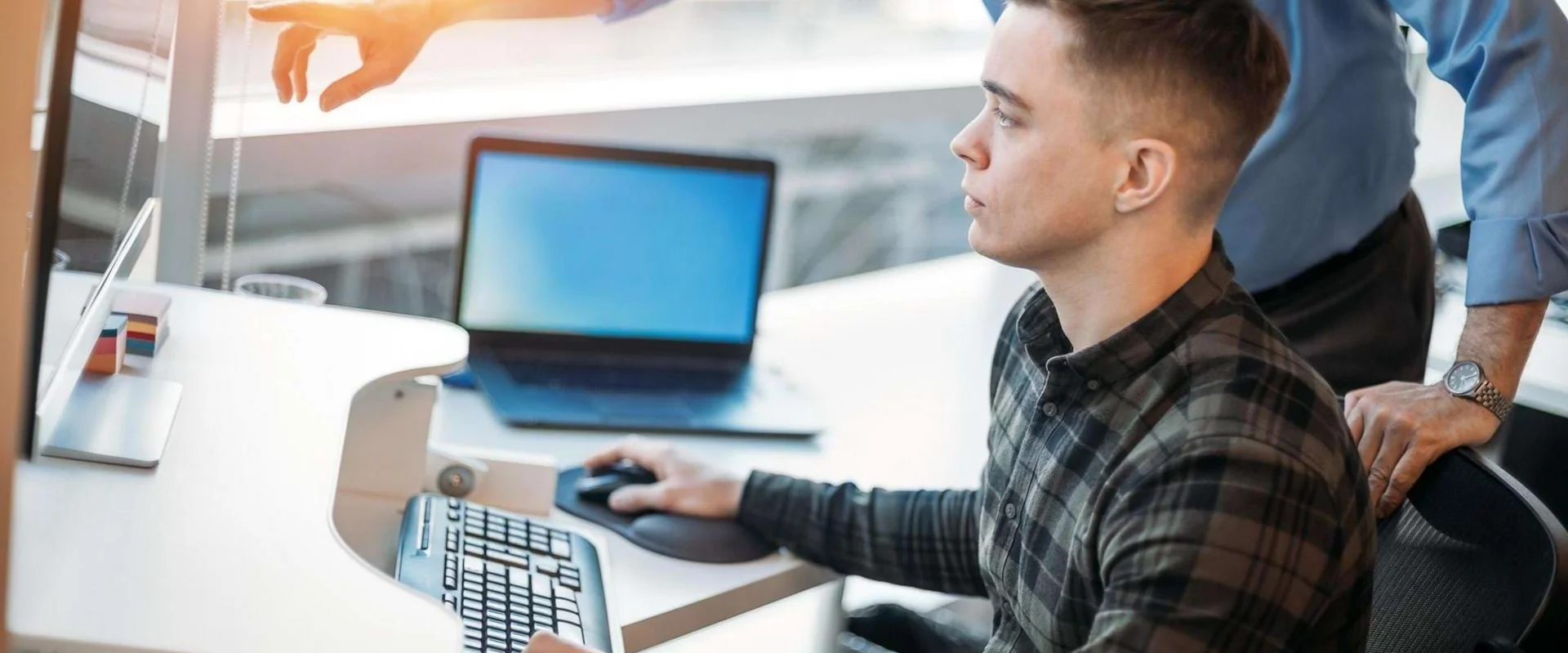 Auszubildender Fachinformatiker für Systemintegration arbeitet am Arbeitsplatz mit IT-Technik. Auszubildender Fachinformatiker für Systemintegration arbeitet am Arbeitsplatz mit IT-Technik.