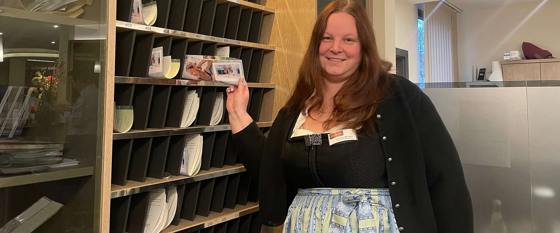 Christina Wichern steht an der Rezeption und lächelt in die Kamera. Christina Wichern steht an der Rezeption und lächelt in die Kamera.