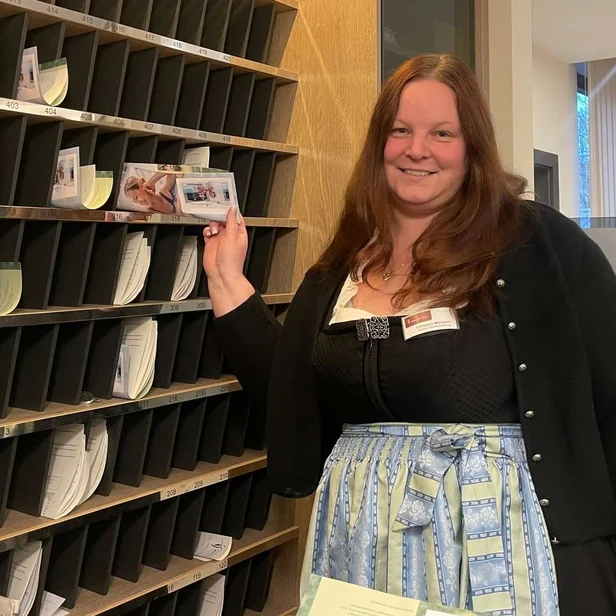 Christina Wichern steht an der Rezeption und lächelt in die Kamera.