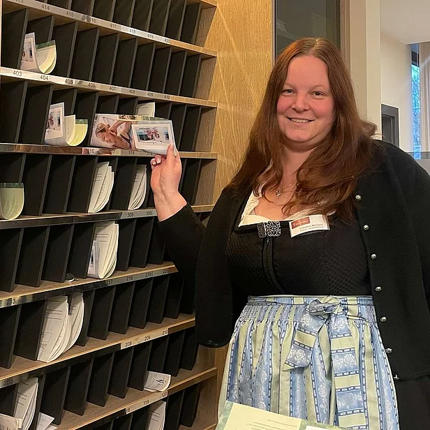 Christina Wichern steht an der Rezeption und lächelt in die Kamera. Christina Wichern steht an der Rezeption und lächelt in die Kamera.