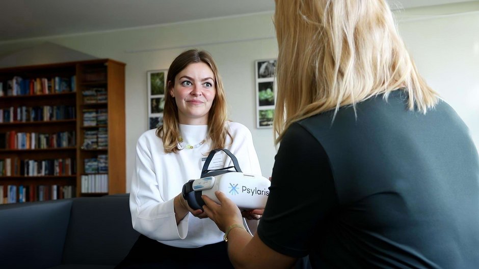 Therapeutin Johannesbad Fachklinik Hochsauerland reicht VR-Brille und Patientin Therapeutin Johannesbad Fachklinik Hochsauerland reicht VR-Brille und Patientin
