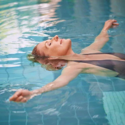 Frau treibt in Wasser der Johannesbad Therme