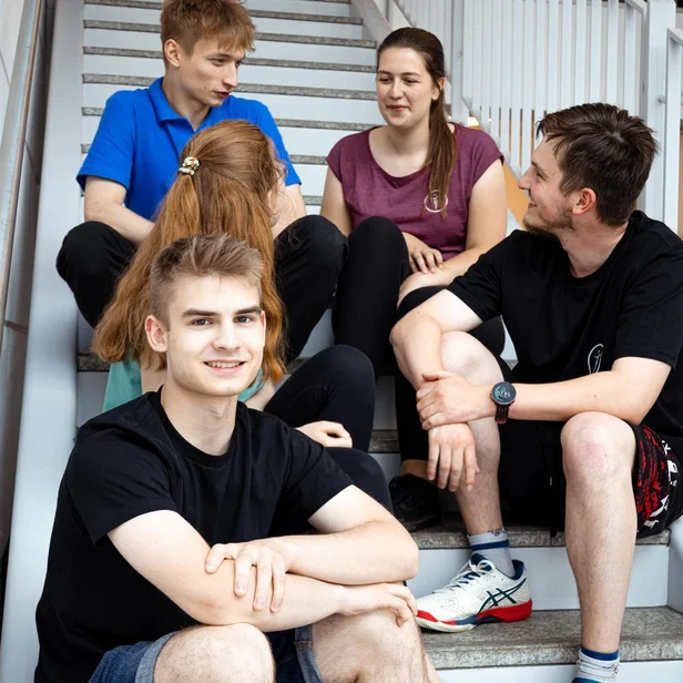 Studierende im dualen Studium Therapie- und Pflegewissenschaften sitzen gemeinsam auf einer Treppe und unterhalten sich. Studierende im dualen Studium Therapie- und Pflegewissenschaften sitzen gemeinsam auf einer Treppe und unterhalten sich.