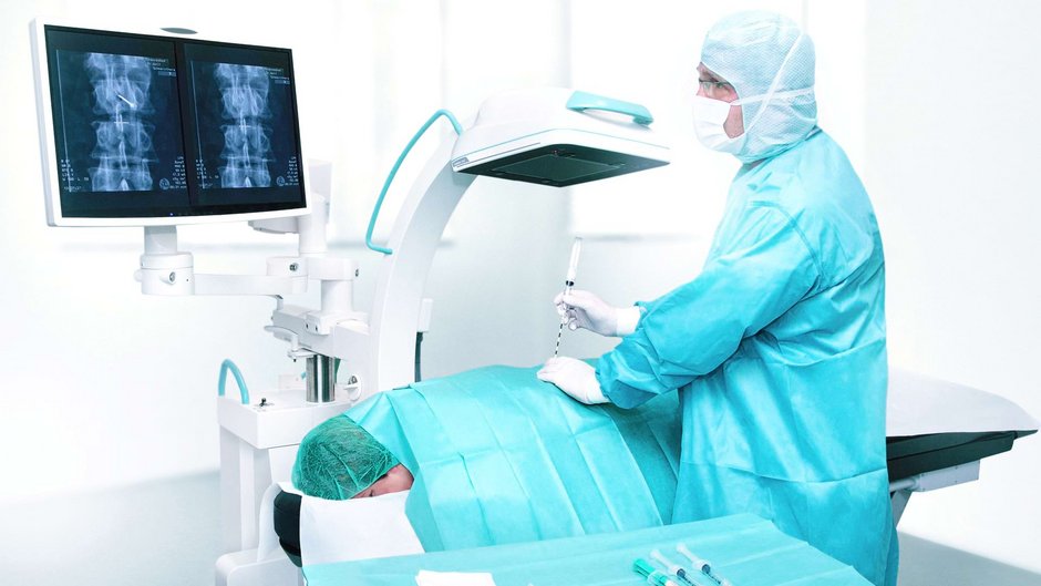 Arzt der Johannesbad Fachklinik Bad Füssing nimmt in OP am Rücken eines Patienten Eingriff vor Arzt der Johannesbad Fachklinik Bad Füssing nimmt in OP am Rücken eines Patienten Eingriff vor