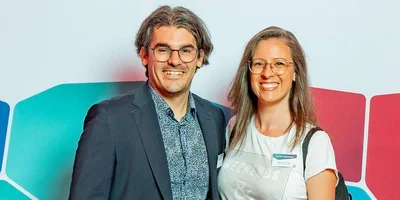 Dr. med  Timo Donate, leitender Oberarzt Johannesbad Fachklinik Saarschleife, mit Kollegin vor Fotowand.