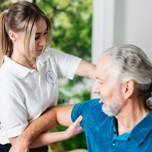 Kristina Mikesch behandelt einen Patienten und erklärt eine Übung.